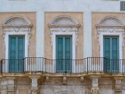 ...che dividono la vasta serie di finestre, alcune con architravi decorati con conchiglie e volute